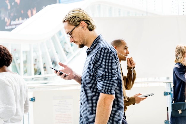 Photo gratuite homme blond envoyant des sms sur son téléphone