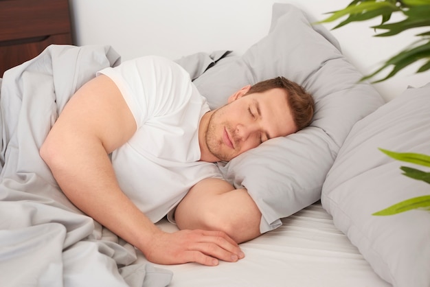 Photo gratuite homme dormant dans le lit confortable