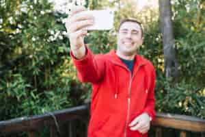 Photo gratuite homme floue prenant selfie dans le parc