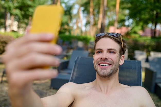 Photo gratuite un homme souriant faisant du selfie et ayant l'air excité