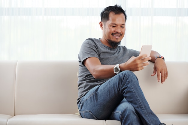 Homme souriant vérifiant son téléphone