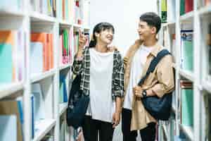 Photo gratuite hommes et femmes portant un sac à dos et recherchant des livres dans la bibliothèque.