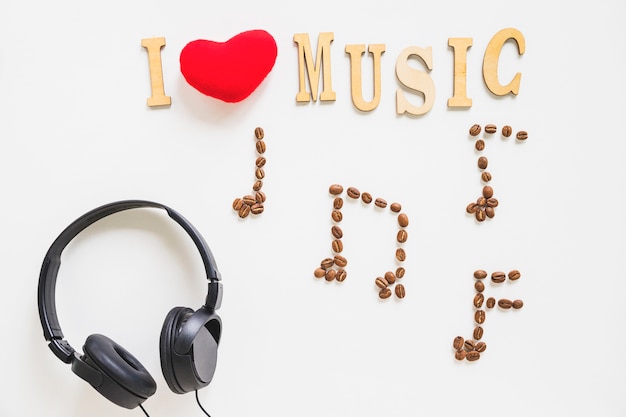 Photo gratuite j'adore le texte de musique avec des grains de café musicaux grillés et un casque sur fond blanc