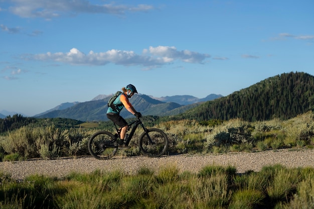 Photo gratuit jeune adulte à l'aide de vélo électrique à la campagne