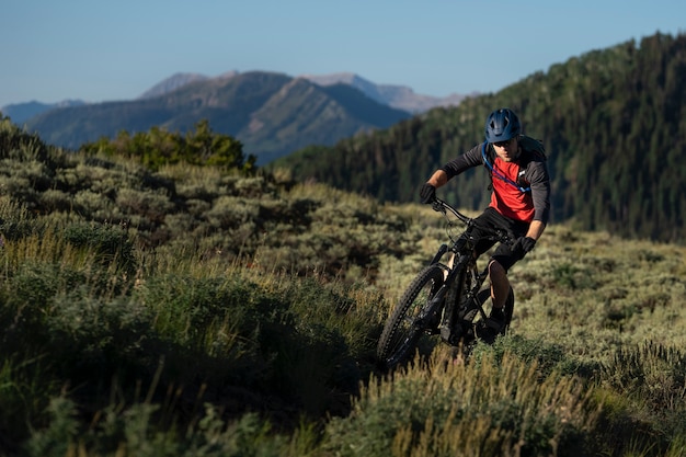 Photo gratuit jeune adulte à l'aide de vélo électrique à la campagne