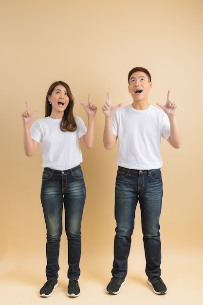 Photo gratuite jeune couple asiatique heureux présentant les symboles de la maison