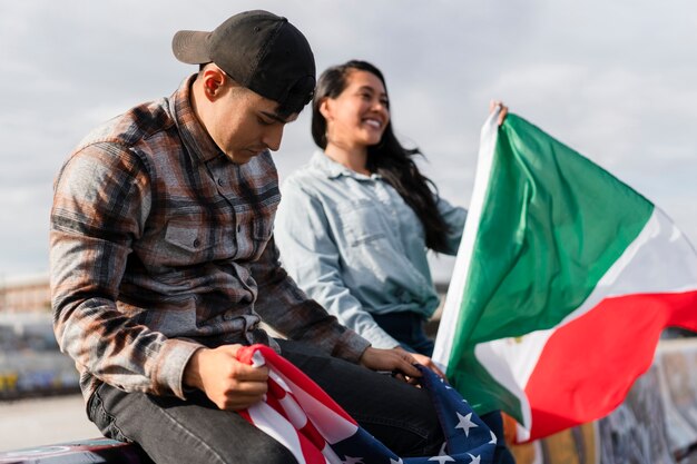 Jeune couple avec des drapeaux à côté de la rivière