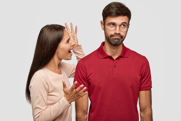 Photo gratuite un jeune couple familial est en conflit. jeune femme européenne brune en colère fait des gestes avec les mains