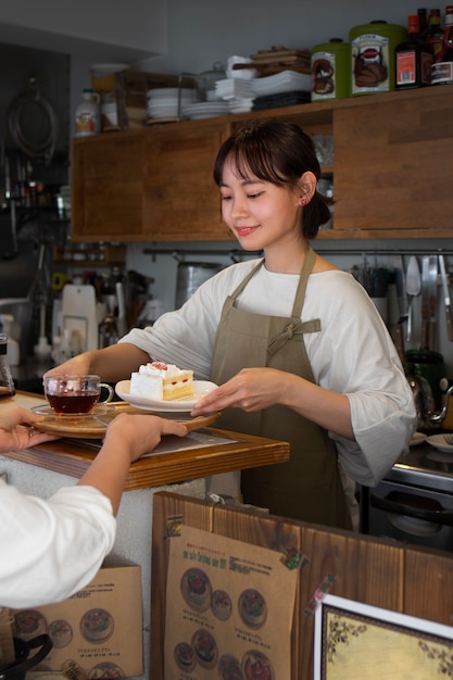 Photo gratuit jeune femme organisant sa pâtisserie