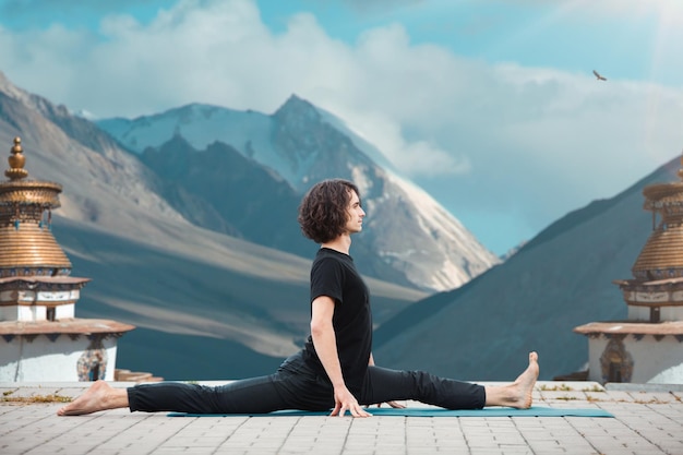 Photo gratuite jeune homme faisant du yoga dans le loft au lever du soleil