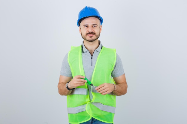 Photo gratuite jeune ouvrier du bâtiment portant un casque de sécurité