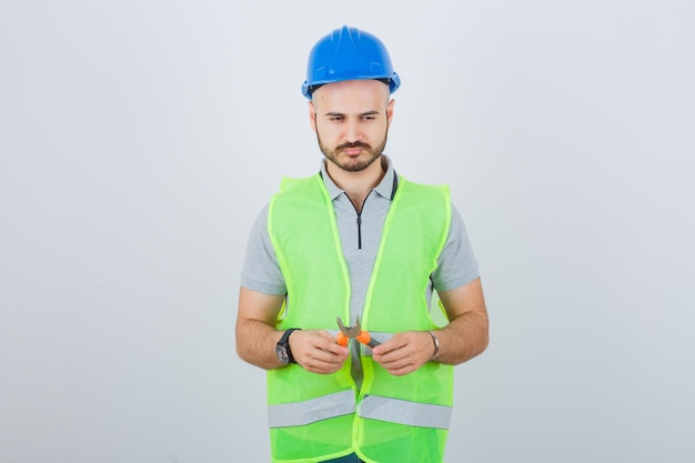 Photo gratuite jeune ouvrier du bâtiment portant un casque de sécurité