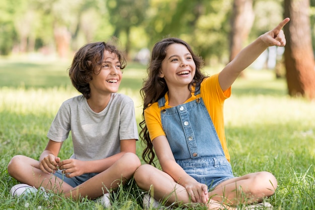 Photo gratuite jeunes amis pointant vers l'extérieur