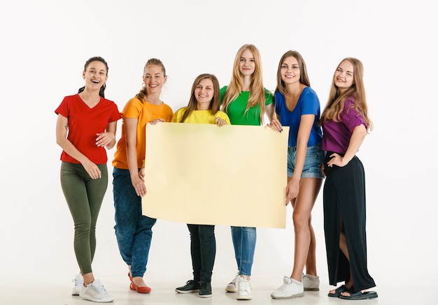 Les jeunes portés dans les couleurs du drapeau lgbt isolés sur le concept de fierté lgbt mur blanc