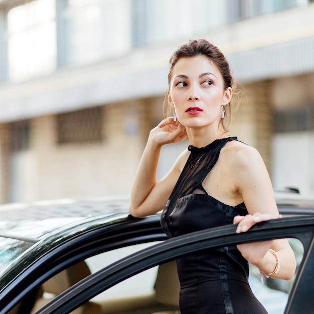 Photo gratuit jolie jeune fille debout près de la voiture