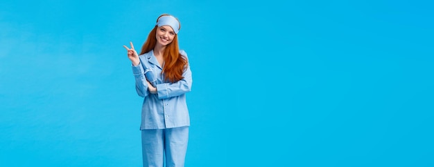 Photo gratuite jolie et tendre femme rousse féminine en vêtements de nuit et masque de sommeil studi vertical pleine longueur