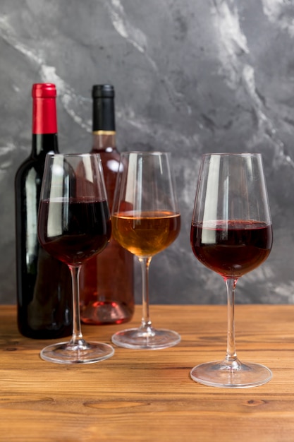 Photo gratuite ligne de bouteilles de vin et de verres à vin