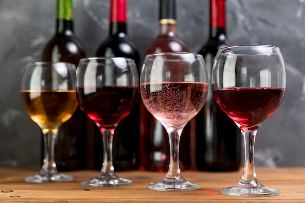 Photo gratuite ligne de bouteilles de vin et de verres à vin