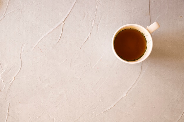 Photo gratuite liquide dans une tasse blanche en céramique sur fond de béton