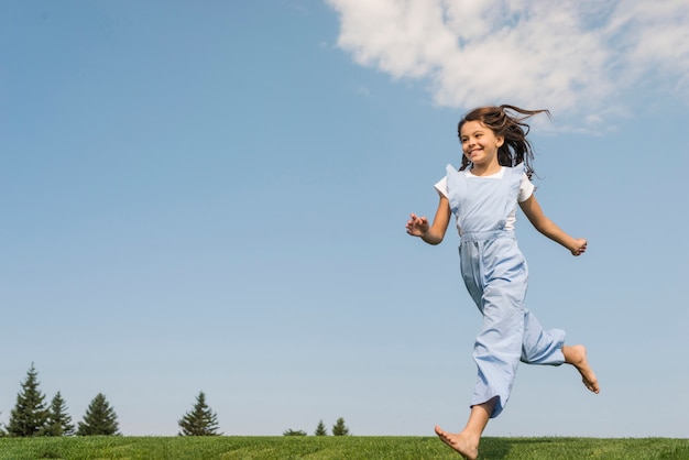 Photo gratuite long shot fille courir pieds nus sur l'herbe