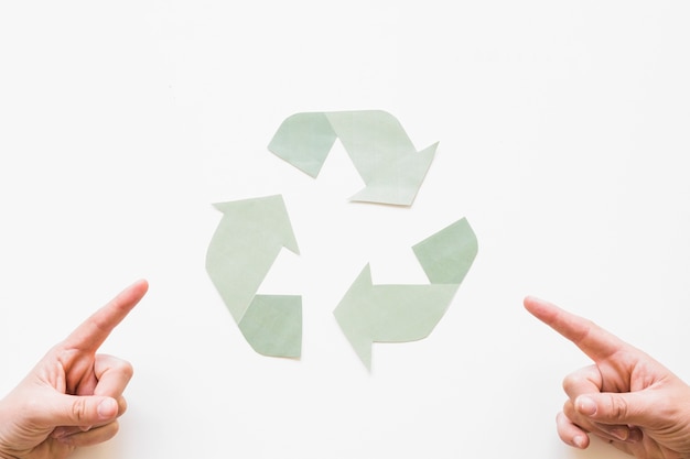 Photo gratuite mains pointant au logo de recyclage