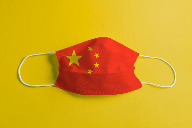 Masque chirurgical sur fond jaune avec le drapeau de la Chine