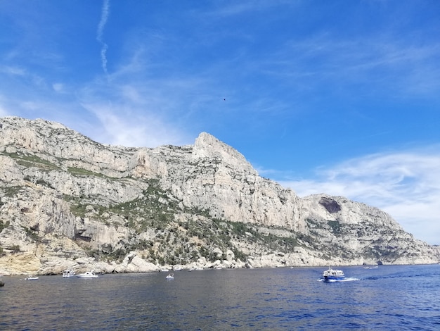 Photo gratuite massif des calanques entouré par la mer sous un ciel bleu et la lumière du soleil en france