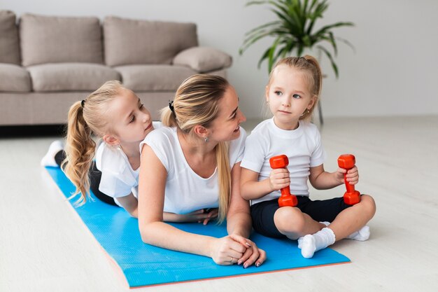 Photo gratuite mère, poser, filles, yoga, natte, maison