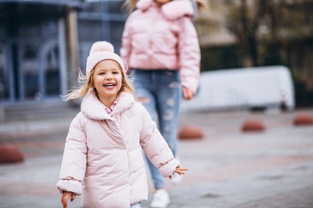 Mère avec sa petite fille vêtue d'un linge chaud en dehors de la rue