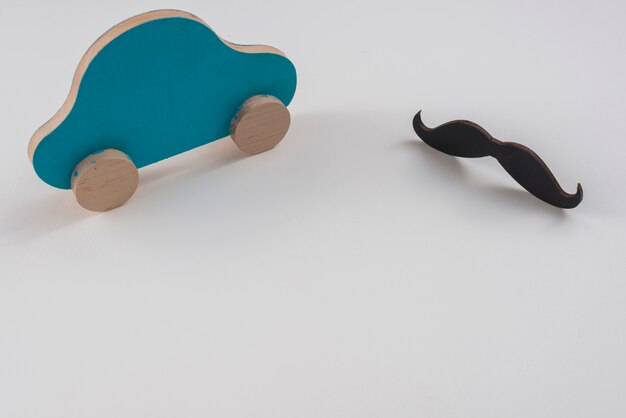 Photo gratuite moustache noire avec petite voiture sur la table