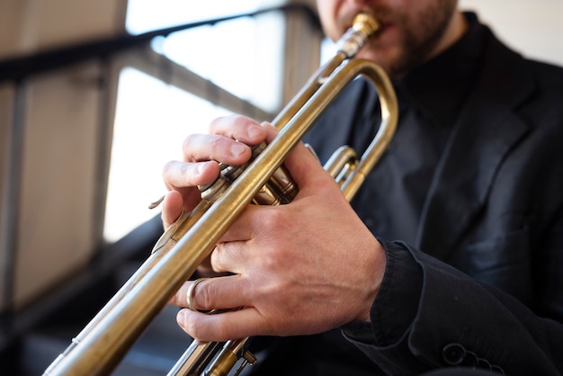 Photo gratuite musicien jouant de la trompette à l'intérieur