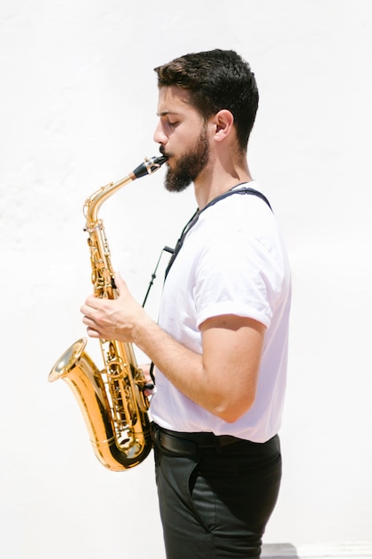 Photo gratuite musicien latéral jouant au saxophone