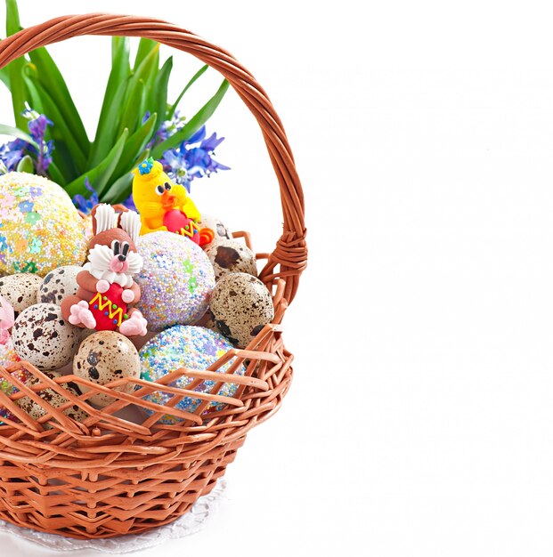 Oeufs de Pâques colorés dans un panier sur fond blanc