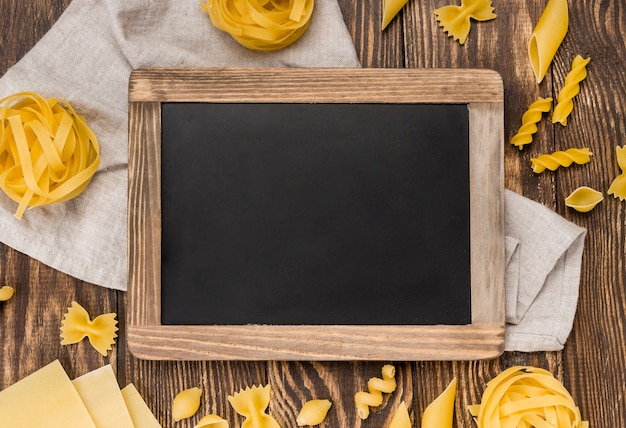 Photo gratuite pâtes italiennes en cuillères à côté du tableau noir