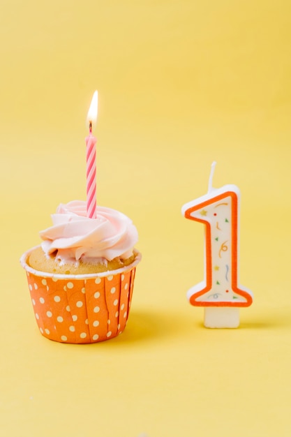 Photo gratuite petit gâteau d'anniversaire avec une bougie allumée