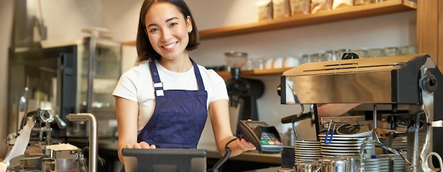 Photo gratuit les petites entreprises et les gens souriants femme asiatique barista travaillant dans un café donnant crédit terminal pos