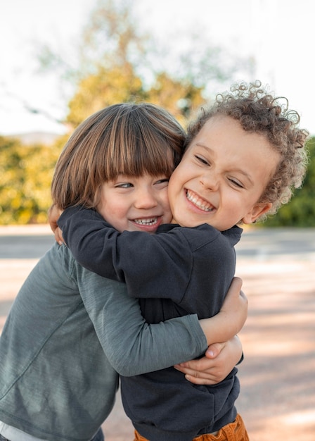 Photo gratuite petits garçons étreignant à l'extérieur