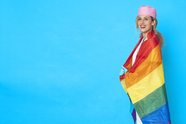 Photo gratuit photo d'une infirmière souriante avec un drapeau lgbt sur un fond bleu