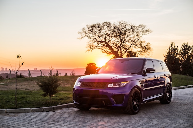 Photo gratuit une photo en jeep bleue au coucher du soleil.