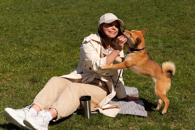 Photo gratuit plein coup de femme jouant avec un chien mignon