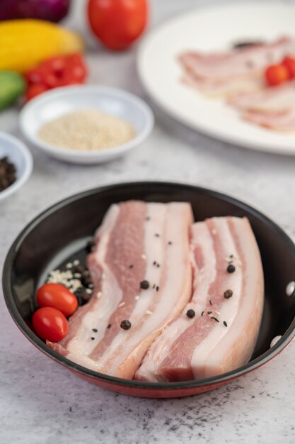 Photo gratuite poitrine de porc dans une poêle avec des graines de poivron tomates et épices