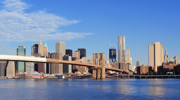 Photo gratuite pont de brooklyn avec panorama sur les gratte-ciel de manhattan le matin avec nuages et ciel bleu au-dessus de l'east river à new york city