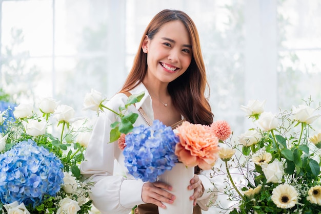 Photo gratuit portrait asie femme fleuriste sourire arrangeant des fleurs dans un magasin de fleurs magasin de conception de fleurs bonheur souriante jeune femme faisant un vase de fleurs pour les clients préparant des travaux de fleurs à partir d'une entreprise à domicile