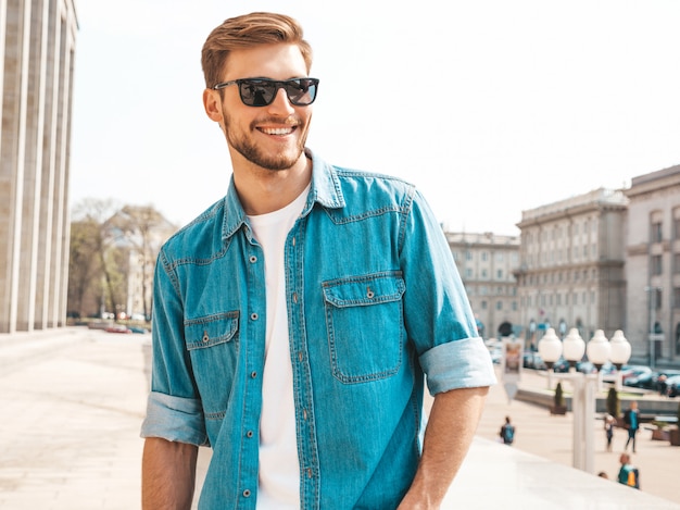 Portrait de beau modèle d'homme d'affaires lumbersexual hipster élégant souriant. Homme vêtu de vêtements veste jeans.