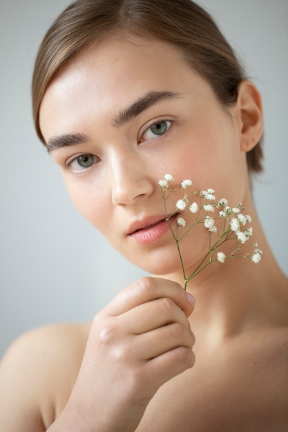 Photo gratuite portrait de belle femme à la peau claire posant avec des fleurs de souffle de bébé