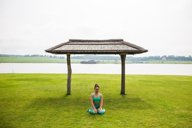 Photo gratuit portrait de bonheur jeune femme pratiquant le yoga à l'extérieur