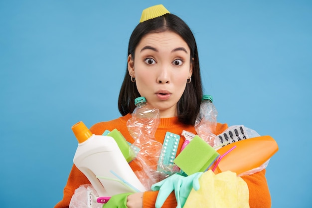 Photo gratuite le portrait d'une femme asiatique au visage surpris contient des bouteilles vides en plastique et des ordures pour le recyclage afin