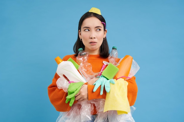 Photo gratuite portrait d'une femme asiatique pensant tenant des bouteilles en plastique vides tri des déchets recyclables litière à rec