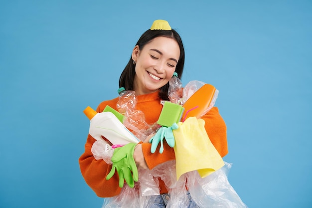 Photo gratuite portrait d'une femme asiatique souriante étreignant des bouteilles en plastique vides et des éco-activistes de déchets recyclables comme