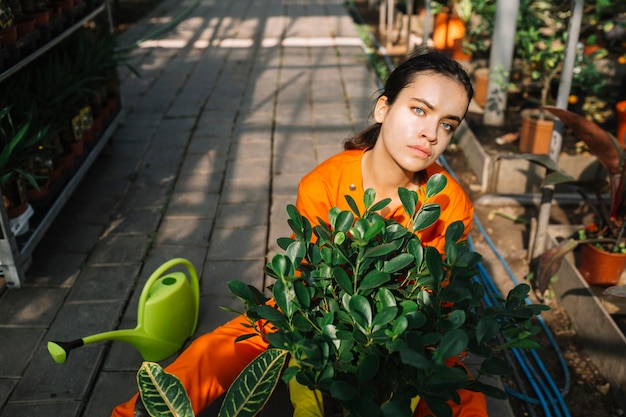 Photo gratuite portrait d'une femme jardinier avec plante en pot